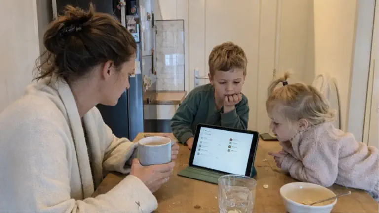Een gewone ochtend aan een Nederlandse keukentafel met kinderen en een tablet waarop een visuele planner staat.